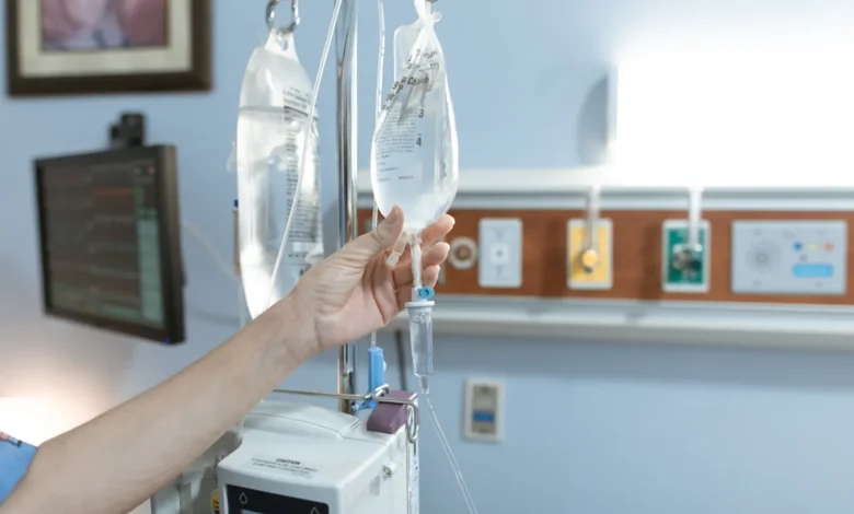 Close-up image of an IV drip and hand in a hospital room, illustrating medical care