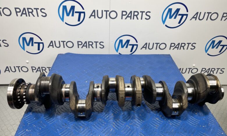 BMW N57D30C engine crankshaft on a blue workshop mat